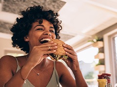 Woman smiling while enjoying meal in restaurant