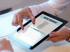 Patient reviewing dental insurance form on tablet in office