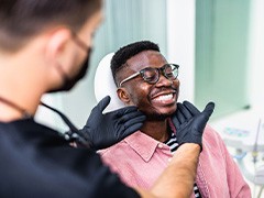Dentist looking at patient's smile in treatment room