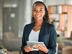 Smiling woman holding tablet in office