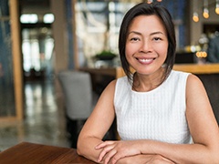 smiling woman sitting at a table 