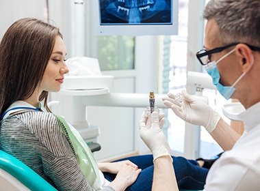 dentist showing a dental implant to a patient 