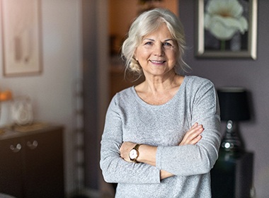 Older woman smiling with her arms crossed