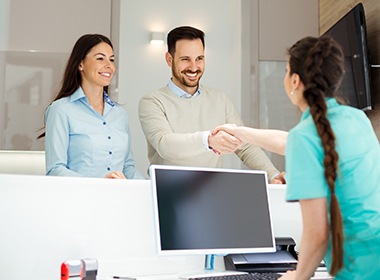 man shaking hands with front desk worker