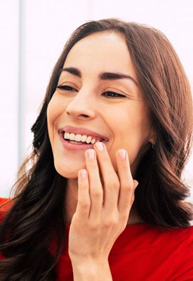 Woman admiring her smile in a small mirror