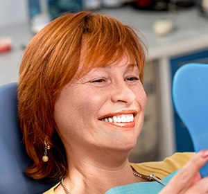 woman smiling into blue mirror