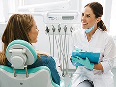 Smiling dentist taking notes on clipboard