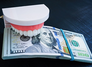 Mouth mold biting down on stack of money