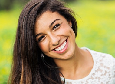 woman in green field smiling