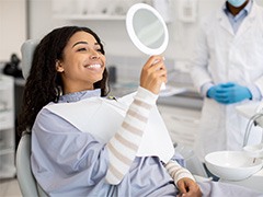 Woman smiling while looking at reflection in mirror