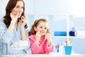 mother and daughter learning to floss using tips from their whitehall dentist