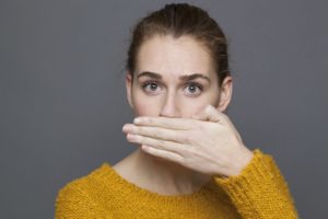 woman bad breath covering mouth