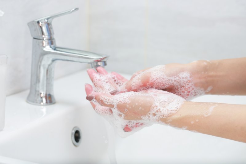 Woman washing her hands with soap and water