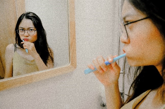 Woman brushing her teeth.