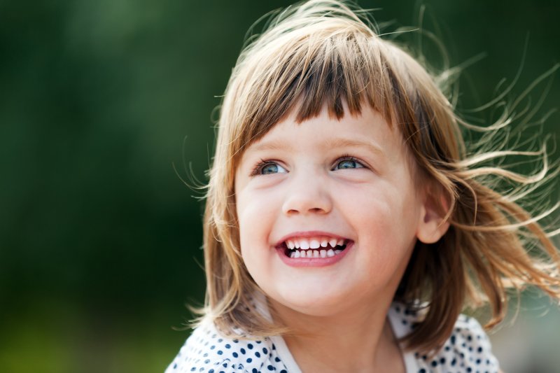 Young girl sitting and smiling outside