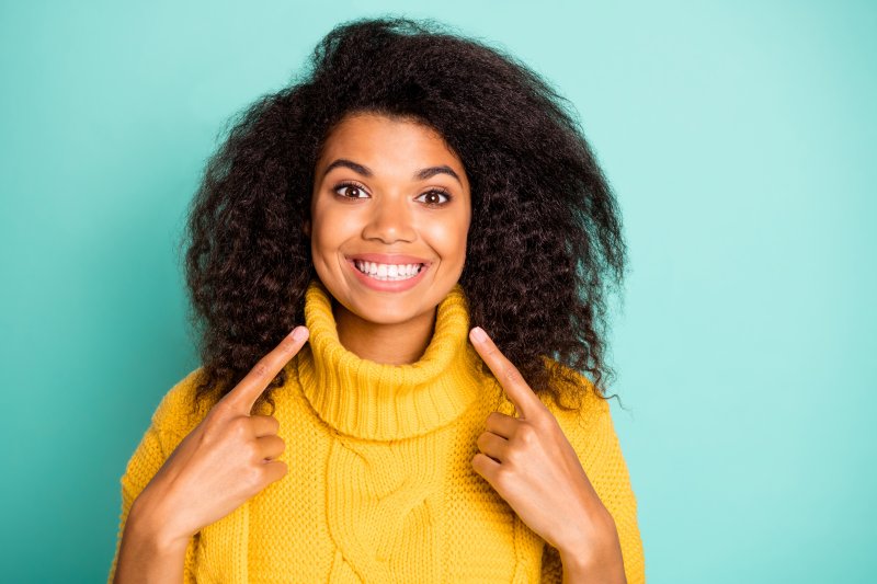 woman pointing at teeth before seeing dentist in Lehigh Valley