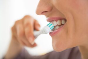 Nose-to-chin profile view of a woman brushing her teeth