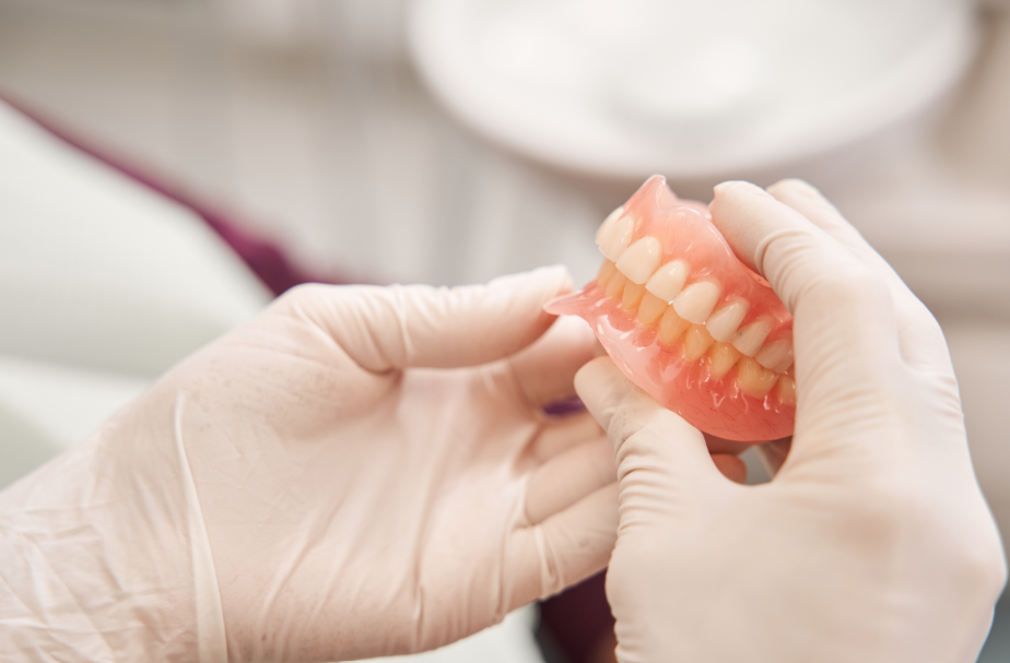 Close up of dentists' hands holding dentures